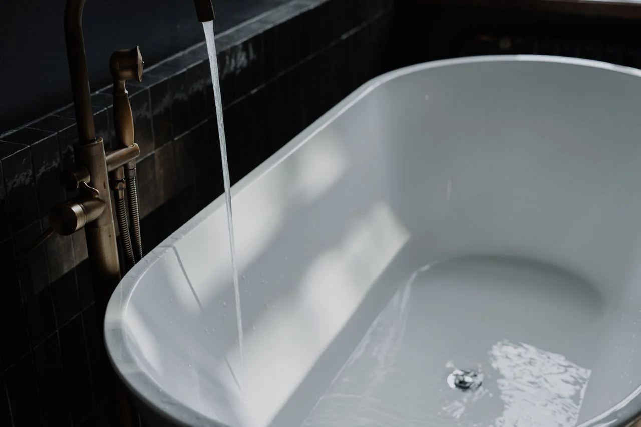 Person pouring water over arm while performing ghusl correctly
